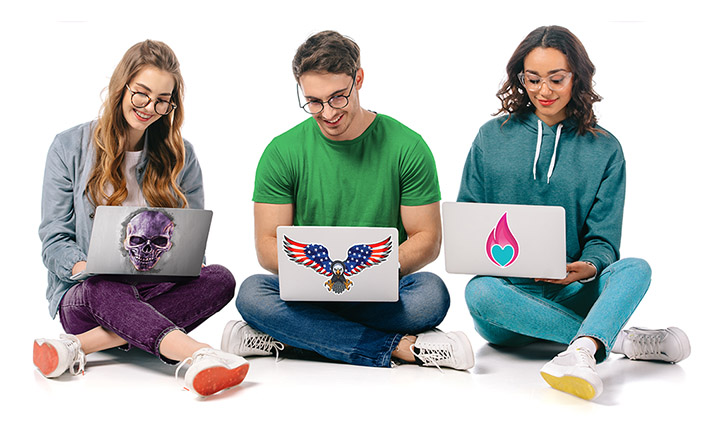 Students using laptops decorated with custom vinyl stickers and vinyl skins.